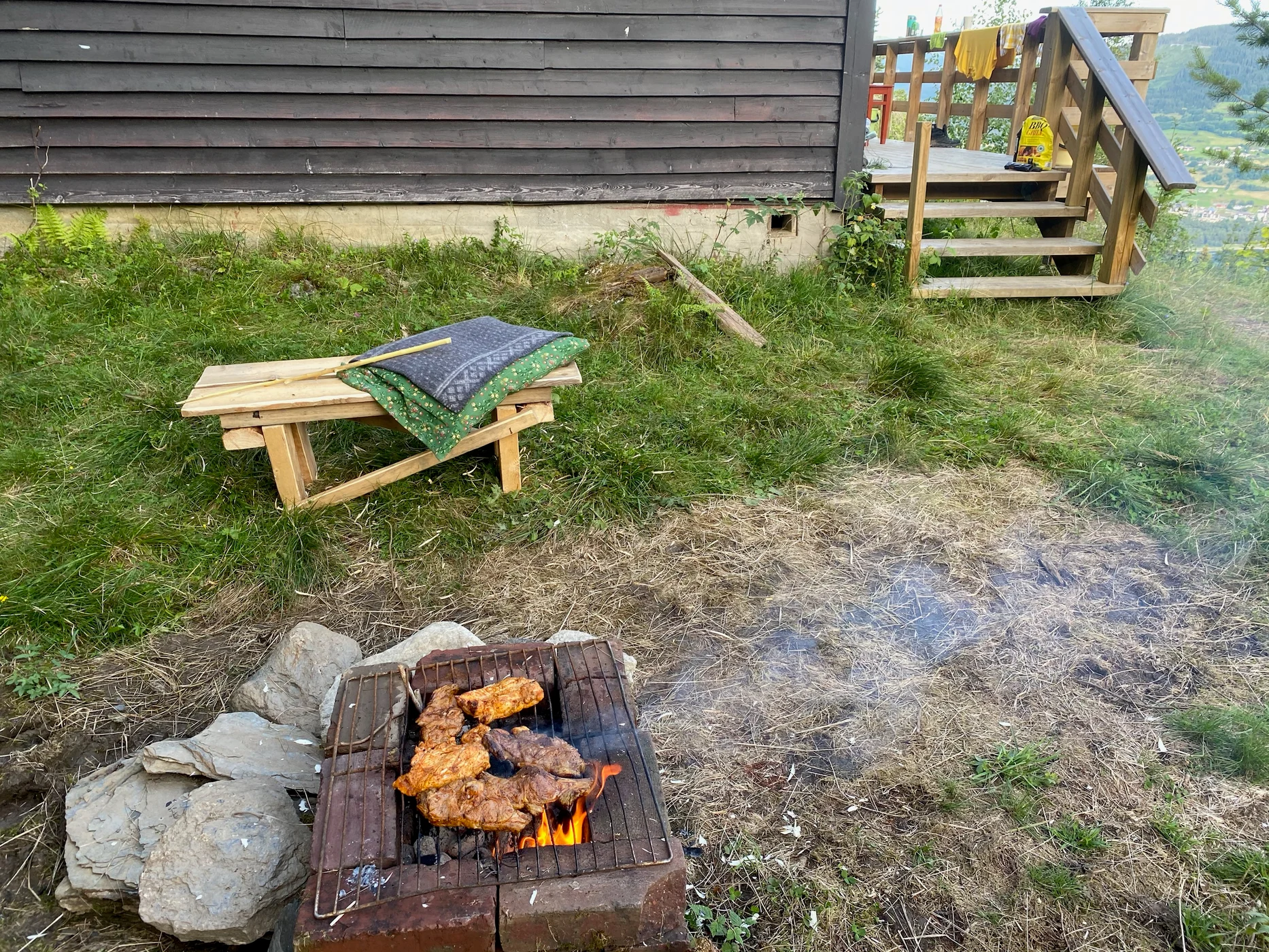 Grilling på hyttedecket med fjellutsikt i bakgrunnen