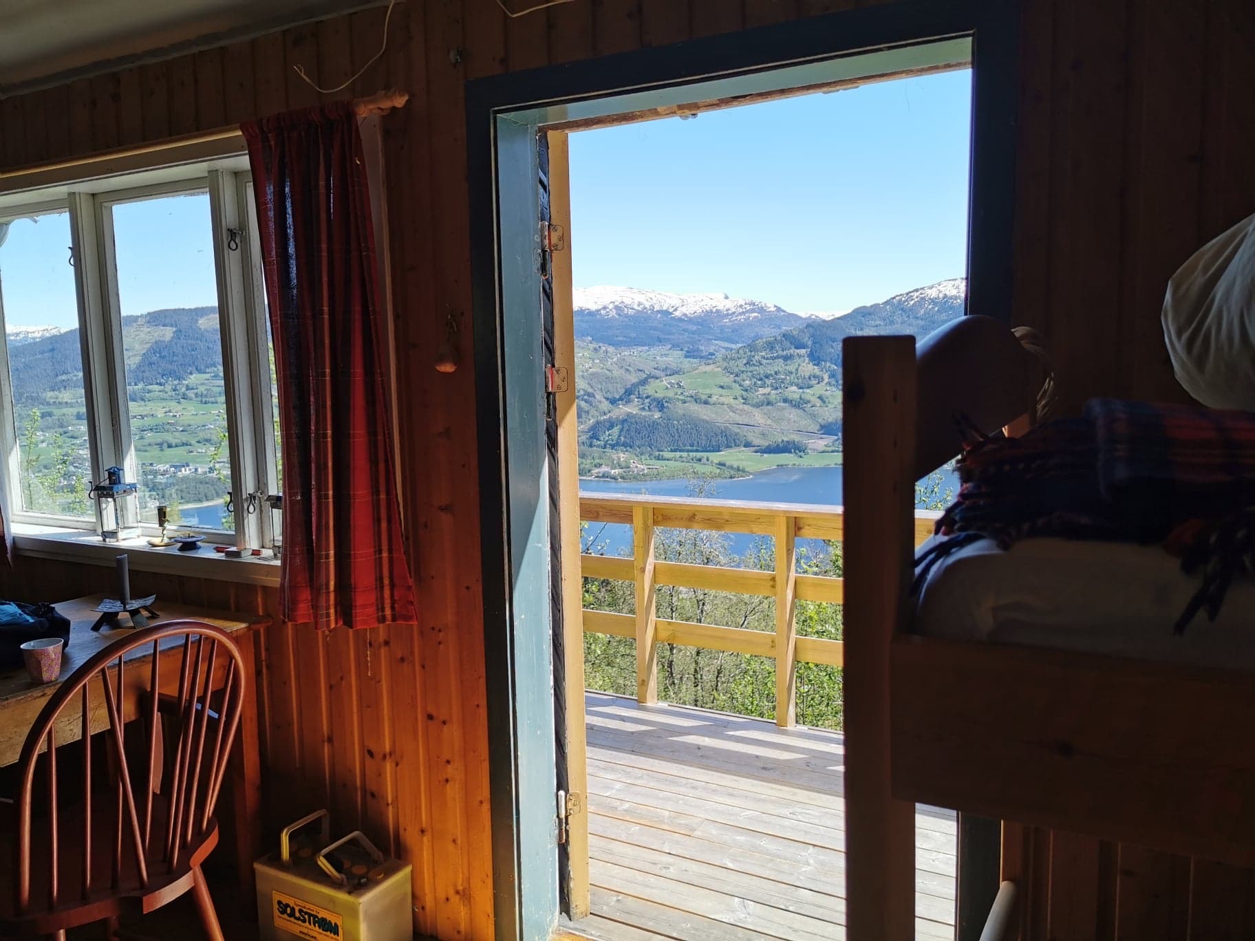 Utsikt frå hytta gjennom døra mot Vossavatnet og snødekte fjell