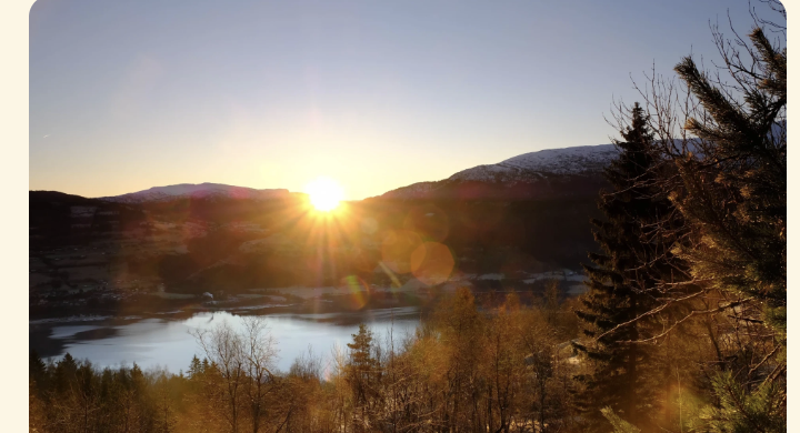 Solnedgang over Voss med fjell, vatn og skog i vinterlys